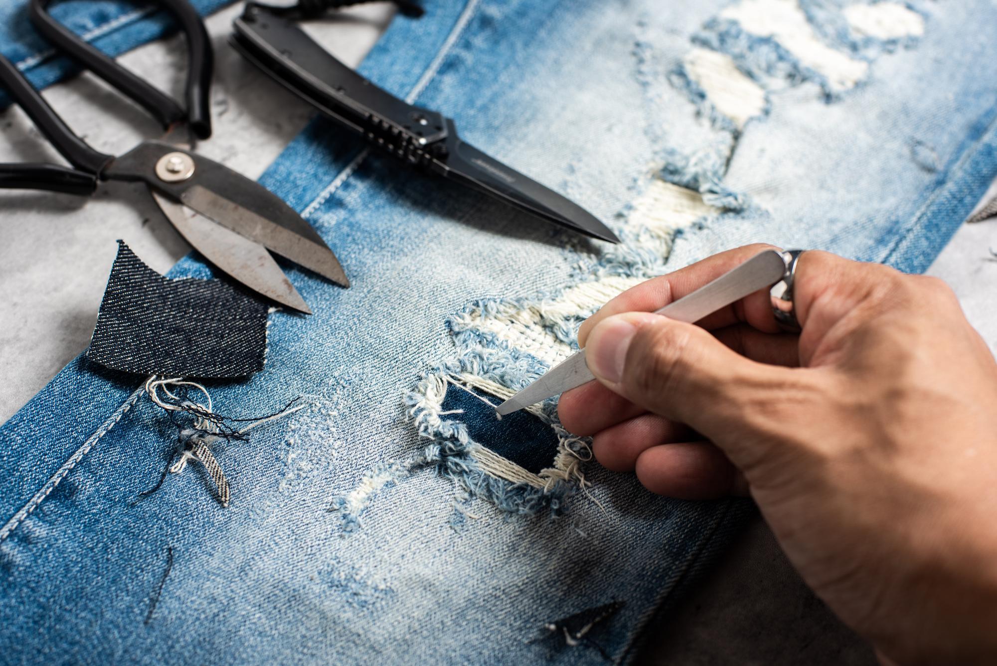 Hand finishing embroidered patch on denim